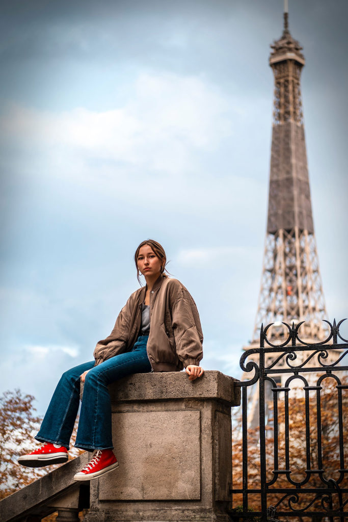Young woman in jeans in front of the Eiffel Tower